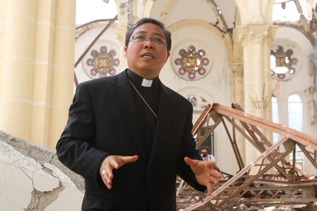 In March 2010, at the ruins of the Haiti cathedral, the papal nuncio, Archbishop Bernardito Auza, gives an explanation of the damages to a visiting delegation from the U.S. conference of bishops.