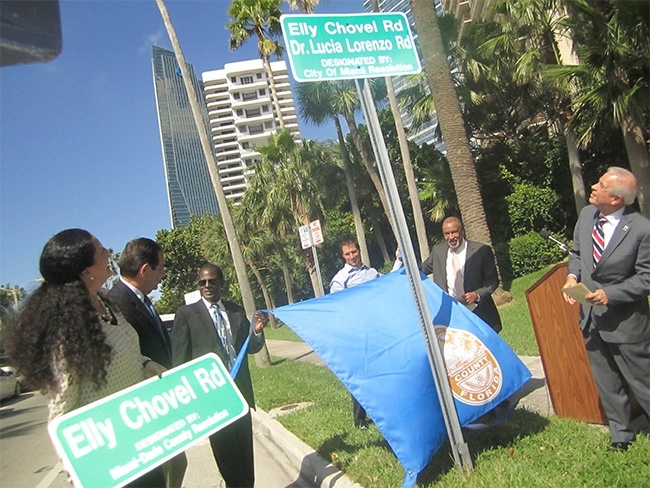 Elly Chovel's daughter, Brigid Prio, holds a new road sign as members of Operation Pedro Pan Group which Chovel founded and Miami Mayor Tomas Regalado, far right, unveil the road marker.