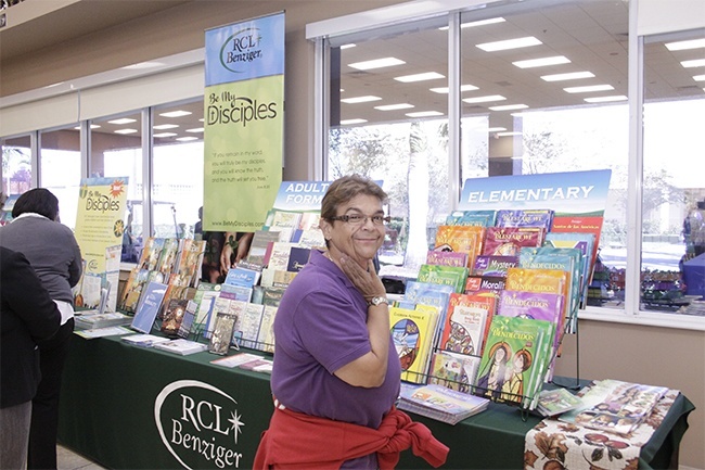 Nora Torra, director of religious education at Sacred Heart Church in Homestead, looks over teaching aids and publications offered by the RCL Benziger company.