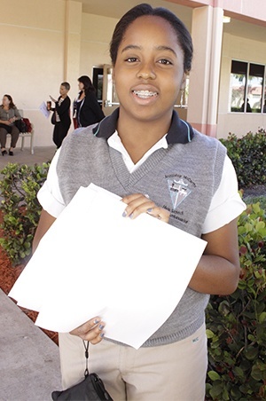 Archbishop Edward McCarthy High School student ambassador, Durcelle Pluviose, an 11th grader, is ready to give instructions so catechists can find the rooms where the workshop sessions are being held.