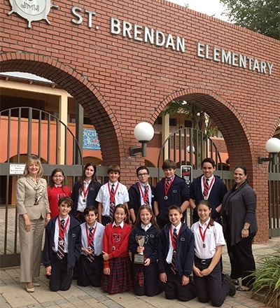 St. Brendan Elementarys seventh graders pose with their medals and second place trophy after the Academic Olympics at Msgr. Edward Pace High School. At left is Elizabeth Furmanick, principal, and at far right is Maria Cristina Capote-Alonso, assistant principal.