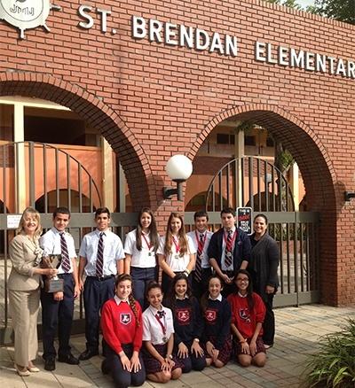 St. Brendan Elementarys eighth graders pose with their medals and first place trophy after the Academic Olympics at Msgr. Edward Pace High School. At left is Elizabeth Furmanick, principal, and at far right is Maria Cristina Capote-Alonso, assistant principal.