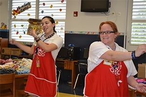 The Build-a-Bear staff from The Falls, Nathalie Villada and Christyann Eliezer, lead the teachers in the "heart ceremony."