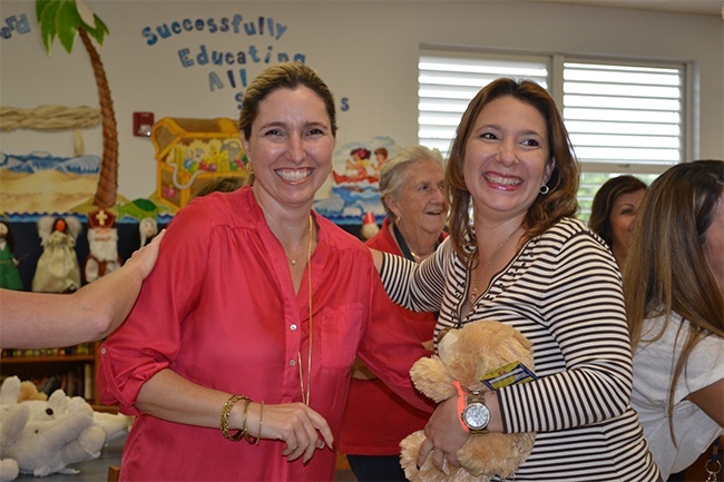 Good Shepherd teacher Aime Dominguez, left, and administrative assistant Milly Briceno Callejas take part in the "heart ceremony."