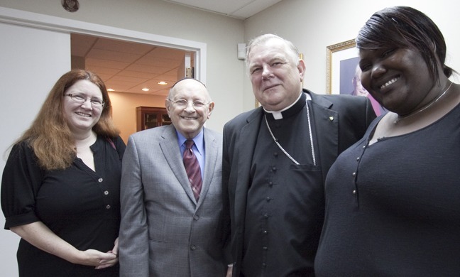 Archbishop Thomas Wenski poses for a photo before meeting Jan. 24 with representatives of South Florida Interfaith Worker Justice and the Florida Immigrant Coalition who are co-coordinating a Wage Theft Task Force in South Florida. Visiting the archbishop were, from left: Jeanette Smith, executive director of the South Florida Interfaith Worker Justice; Rabbi Solomon Schiff, president of the group's board of directors; and Francesca Menes policy and advocacy coordinator for the Florida Immigrant Coalition.