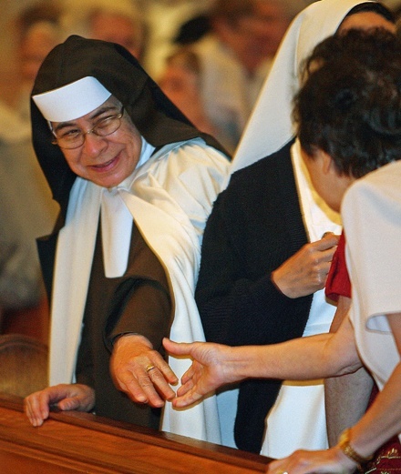 Carmelite Sister Mary Elizabeth Barbosa, who is celebrating her golden anniversary in religious life, reaches out to offer a sign of peace to fellow golden jubilarian Sister Christine Elizabeth Tenn, a Franciscan Sister of Allegany.