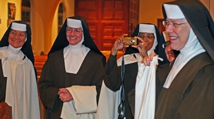 A Carmelite sister takes a photo of fellow Carmelite Sister Mary Elizabeth Barbosa, who is celebrating her golden anniversary as a religious, as other Carmelites watch.