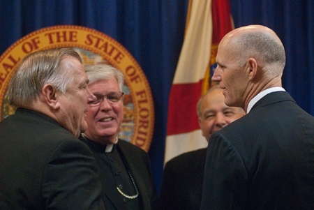 Archbishop Thomas Wenski, Bishop Frank Dewane of Venice and Bishop Felipe Estevez of St. Augustine speak with Florida's Gov. Rick Scott.