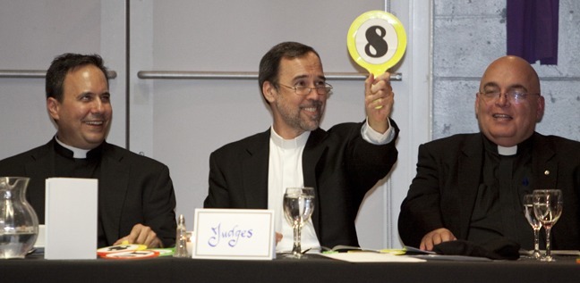 Father Alejandro Rodriguez Artola, pastor of St. Catherine of Siena Parish in Miami, holds up his score as Father David Zirilli, vocations director, and Father Rolando Garcia, St. Agatha's pastor, wait their turn.