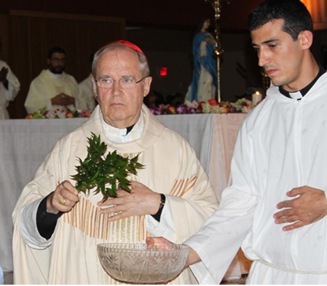 Cardinal Paul Cordes with archdiocesan seminarian  Ivan Rodriguez blesses the congregation with Holy Water during the Mass he celebrated at Good Shepherd Church.