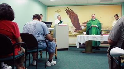 Father Robert Cid of Radio Paz and St. Patrick Parish in Miami Beach, preaches an abbreviated homily during the Mass, for the benefit of airport employees who are on a meal break and travelers who might have to catch flights.