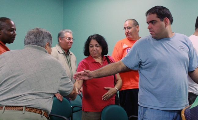 Participants at the first Mass at Miami International Airport exchange the sign of peace.