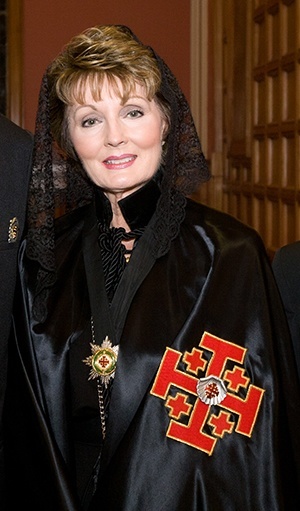 Lady Delores Wolff poses for a photo wearing the traditional attire of the female members of the Knights of the Holy Sepulcher after a recent Mass at St. Mary Cathedral in Miami.