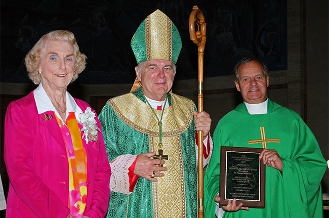 Marjorie Wessel, president of the Catholic Educators Guild poses with Archbishop Thomas Wenski and St. Thomas University President Msgr. Franklyn Casale after he received his Lumen Christi award from the guild.