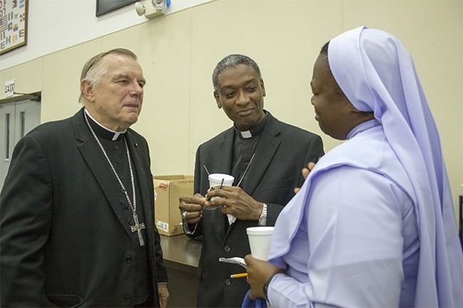 After the opening Mass of the Catechetical Conference, Archbishop Thomas Wenski and his guest, Bishop Chibly Langlois of Les Cayes, Haiti, speak with a local sister.