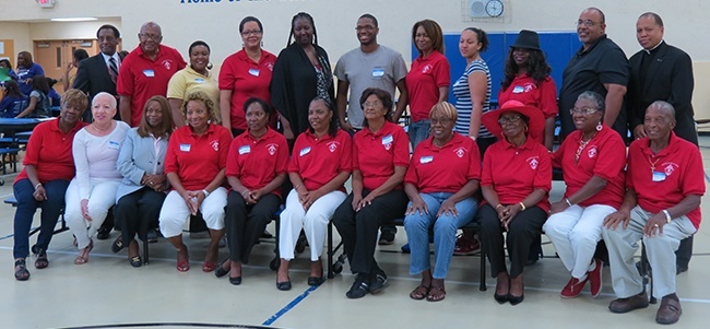 After their lunch break, volunteers with the Office of Black Catholic Ministry pose for a picture with Father Anthony Bozeman (right).