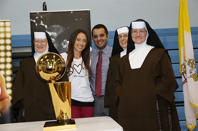 The Carmelite Sisters who work at Archbishop Carroll High School pose with the Heat trophy and Brandon Lopez, alumni relations director and Tara Myers, development director. From left: Sister Grace Helena, Sister Madeleine and Sister Rosalie Nagy, principal.