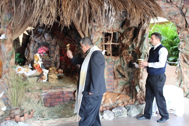 Belen Jesuit School President Father Pedro Suarez blesses the nativity scene at the school in front of the sixth grade class and members of the faculty.