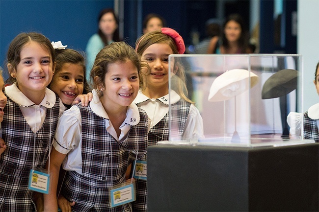 Students from St. Hugh School in Miami examine a zucchetto worn by Blessed John Paul II during a Nov. 5 youth rally in honor of the future saint at St. Thomas University in Miami.