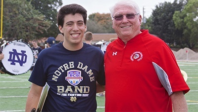 Paul D. Ott, Cardinal Gibbons' principal and a Notre Dame alumnus, poses for a photo with Alex Romeu, a Gibbons alumnus and current member of the Notre Dame marching band.