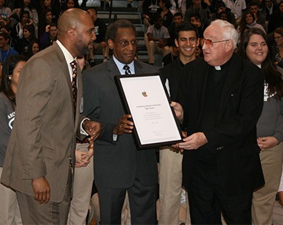 Richard Jean, principal at Archbishop Edward McCarthy High School, left, receives the Apple Distinguished School award from the school's president and supervising principal, Father Brendan Dalton, as Donald Edwards, associate superintendent of schools for the archdiocese, looks on. McCarthy High received the award in recognition of its one-to-one iPad program, the first in the archdiocese.