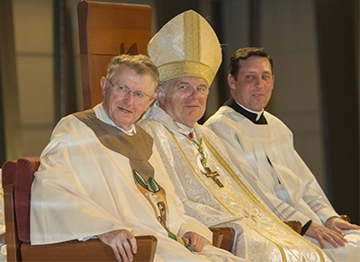 Listening to Thomas Abraham speak about his father, from left: Msgr. Jude O'Doherty, pastor of Epiphany Parish, Archbishop Thomas Wenski and his priest-secretary and master of ceremonies, Father Richard Vigoa.