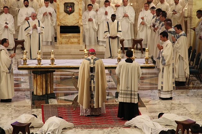 Archbishop Thomas Wenski stands as the candidates lie prostrate on the cathedral sanctuary during the Litany of the Saints.