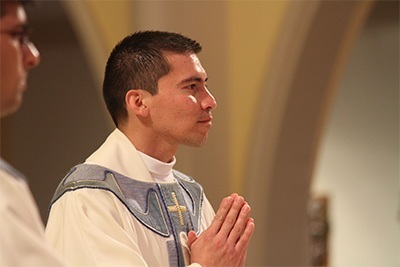 Newly-ordained Father Fredy Yara stands in the sanctuary after being vested as a priest.