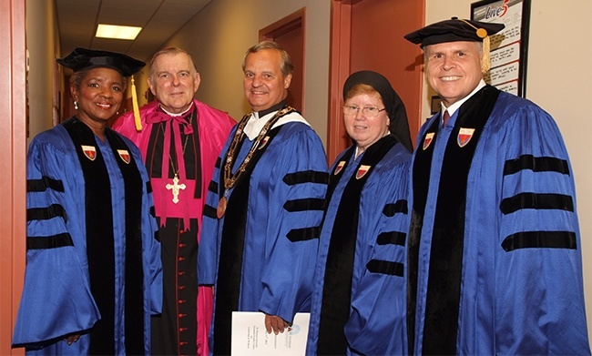 St. Thomas University honorary degree recipients Shirley Gibson, left, and Sister Elizabeth Worley, second from right, pose with Archbishop Thomas Wenski, Msgr. Franklyn Casale and, far right, Gregory Swienton, who also was honored during the 2013 graduation ceremony for St. Thomas University.