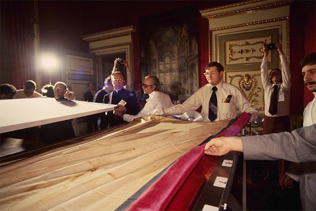 The Shroud of Turin is moved from the board it had been fastened to for the public exhibition to the custom built support table it would be examined on in 1978.