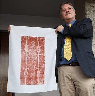 Russell Breault, president of the Shroud of Turin Education Project, holds up an image of what can be seen on the shroud during a presentation in April at St. Gabriel Church, Pompano Beach.