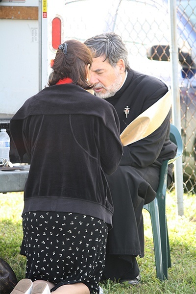 Father Jordi Rivero hears a confession on the feast of Divine Mercy.