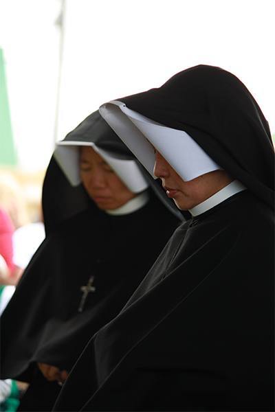 Sister Teresa de la Fuente and Sister Confida Gilera, Sisters of Our Lady of Mercy of Boston, kneel in adoration during exposition of the Blessed Sacrament.