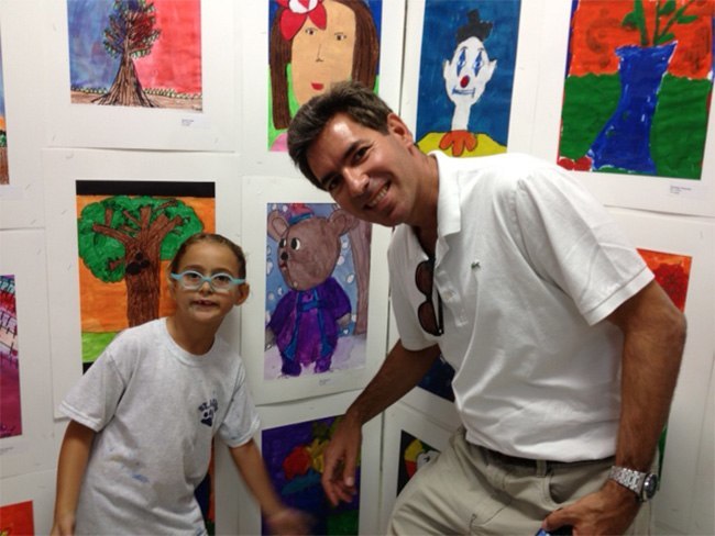 First grader Nika Costantini shows her artwork to her father.