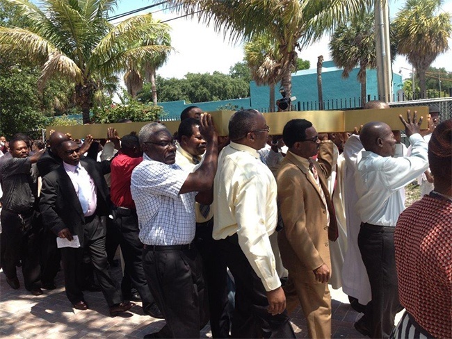 Notre Dame d'Haiti parishioners carry the cross in procession to where it will be raised atop their new church.