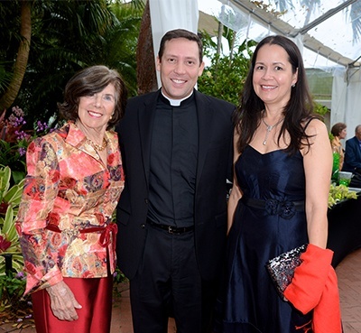 Bunny Bastian, Father Richard Vigoa, and Raphael Bastian pose for a photo at the archdiocesan gala kick-off event.