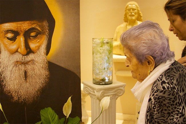 Lourece Gahnoum prays before an image of St. Charbel after being anointed with holy oils bought from the hermit's tomb in Lebanon.