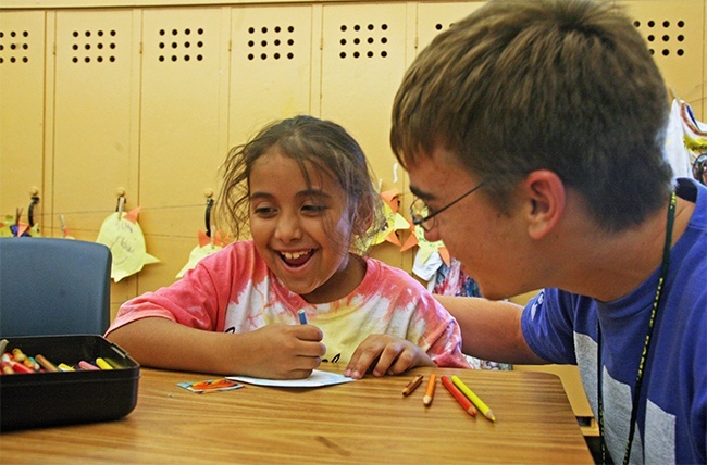 Colin Salandar, 16, of Peoria Notre Dame High School, helps Yiseli Perez, 8, with her art project.