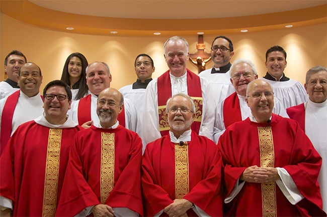 Seminarians and members of Mother of Our Redeemer (back row) pose for a photo with their shepherds after the 25th anniversary Mass: Front row, from left: Father Jimmy Acevedo, Deacon Jose Manuel Gordillo, Father Fernando Compaired, Deacon Antonio Maceo; second row, from left: Father Jorge Cleto, Father Juan Rumin Dominguez, Father Liam Quinn, Father Raul Quesada, Father Jaime Diaz.