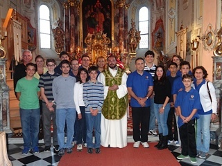 Jesuit Father Christian Saenz (95) poses for a picture with members of the overseas study group after celebrating Mass at St. Thomas the Apostle Church in Tulfes, Austria.