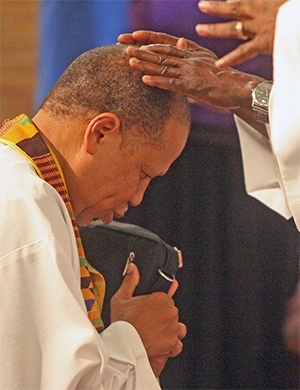 Holy Redeemer administrator Father Alexander Ekechukwu blesses Father Anthony Bozeman before the revivalist speaks.