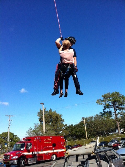 Ana Garcia, principal at Pace High School, takes an active role in a Fire Department demonstration during career day.