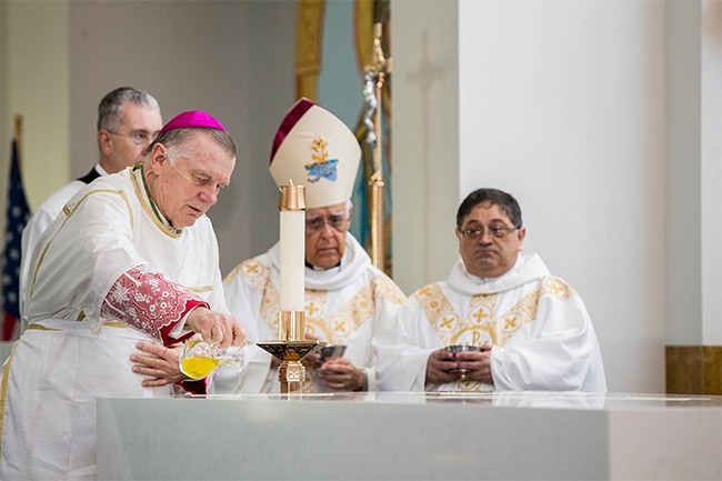 Archbishop Thomas Wenski pours Chrism on the altar of St. Katharine Drexel's new church. Behind him are Archbishop Roberto Lckert Len of Coro, Venezuela, and the church's pastor, Father Enrique Delgado.