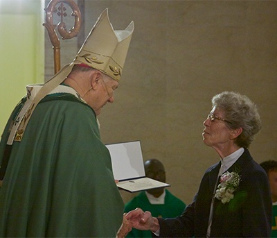 Sister Kathryn Donze of the Sisters, Servants of the Immaculate Heart of Mary, greets Archbishop Thomas Wenski and receives a certificate of recognition for her golden jubilee. She is principal at Our Lady of Lourdes Academy in Miami.