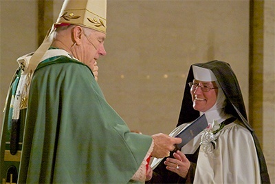 Sister Rosalie Nagy of the Carmelites of the Most Sacred Heart of Los Angeles, principal at Archbishop Coleman F. Carroll High School, receives a certificate of recognition for her silver jubilee from Archbishop Thomas Wenski.