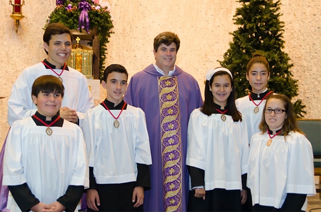 Father Francisco Hernandez poses with Immaculate Conception altar servers who were inducted into the Guild of St. Stephen, from left: Daniel Goncalves (top), Christopher Alfonso, Donald Barraque, Guadalupe Diaz, Kathleen Rios and Anailis Oscariz.