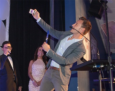 Kevin Ozebek of WSVN-7 takes a "selfie" of himself and the audience after receiving the award for Best Use of Social Media.