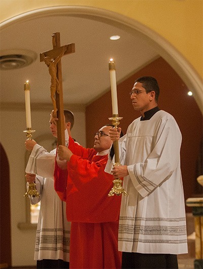 Deacon Edgardo Farias displays the cross during the service.