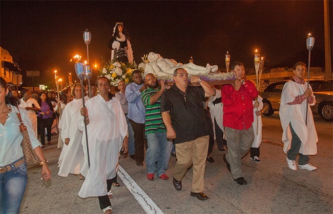 Manuel Aguero, left, and Trinidad Calero, right, lead other men carrying an image of Jesus in procession.