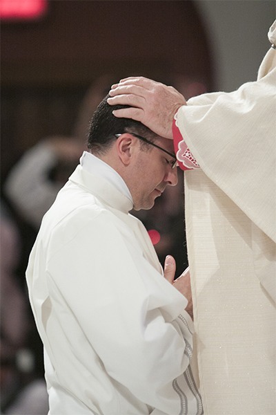En completo silencio, el Arzobispo Thomas Wenski impone las manos sobre el Diácono Matías Hualpa, ordenándolo "sacerdote para siempre".